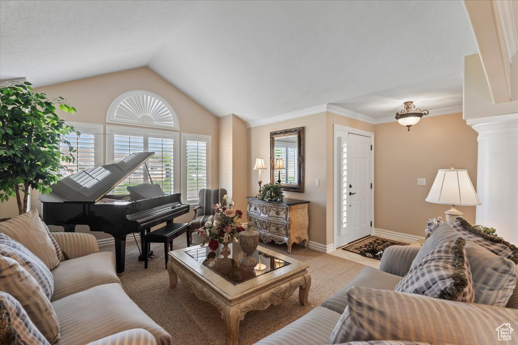 Living area featuring lofted ceiling, carpet floors, baseboards, and ornamental molding