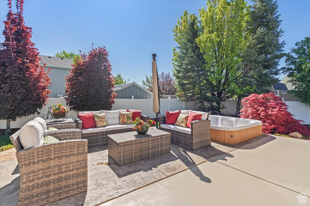 View of patio with a fenced backyard, a hot tub, and an outdoor living space