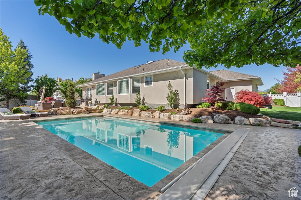 View of swimming pool featuring fence and a patio area