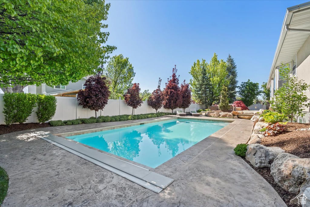 View of pool with a fenced backyard and a patio