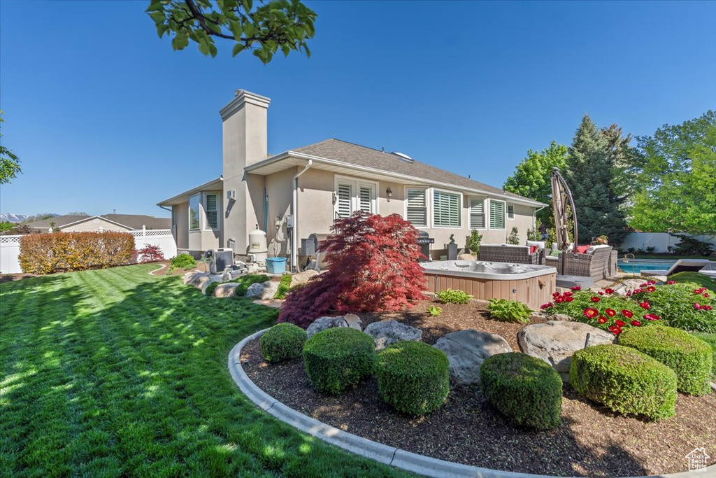 Back of property featuring an outdoor living space, stucco siding, and a chimney