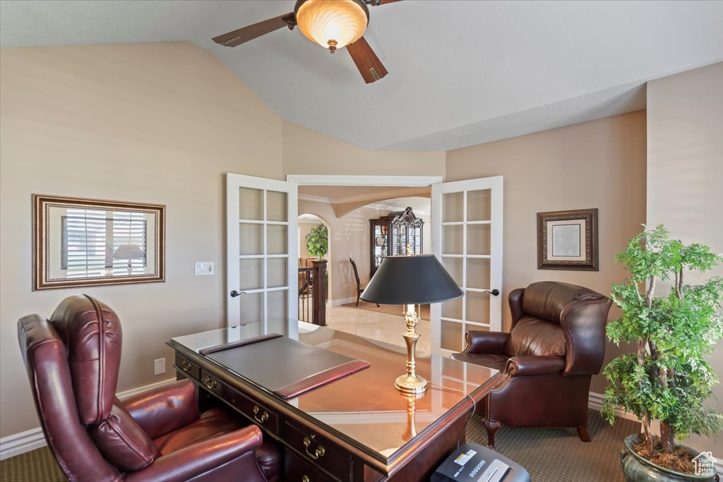 Home office featuring french doors, arched walkways, vaulted ceiling, a ceiling fan, and baseboards