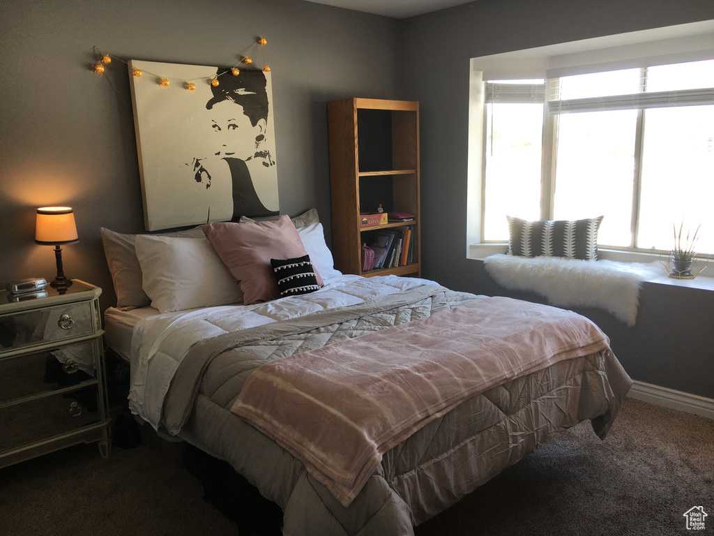 Carpeted bedroom featuring multiple windows