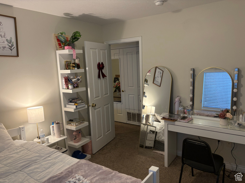 Bedroom with carpet flooring and an office area