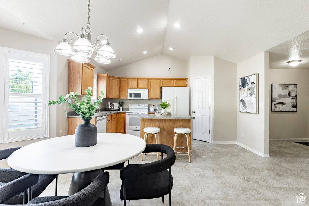 Dining space featuring a chandelier, baseboards, recessed lighting, and high vaulted ceiling