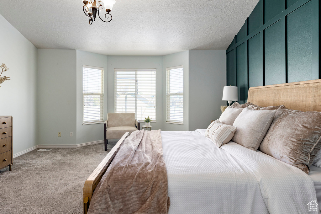 Carpeted bedroom with baseboards and a textured ceiling