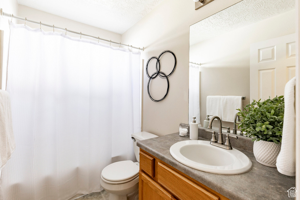 Full bathroom featuring toilet, vanity, and shower / bath combination with curtain
