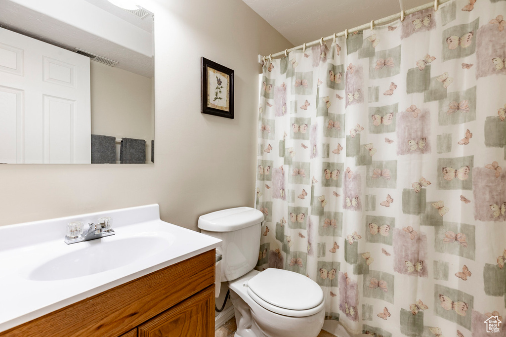 Full bath featuring toilet, vanity, and a shower with shower curtain