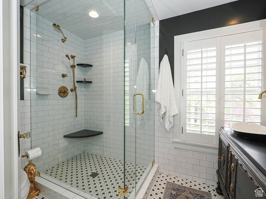 Full bath with a shower stall, vanity, and tile patterned floors