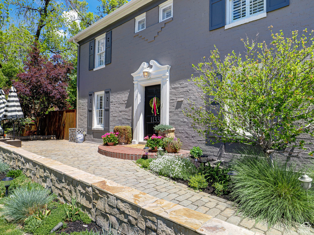 View of front of house featuring fence, stucco siding, and stone siding