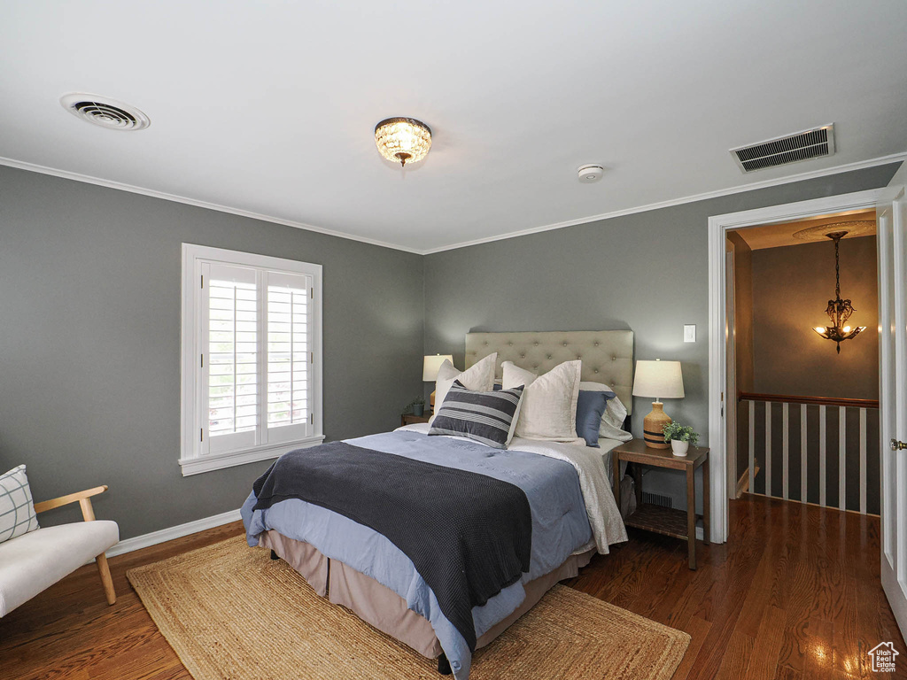 Bedroom featuring wood finished floors, ornamental molding, and baseboards