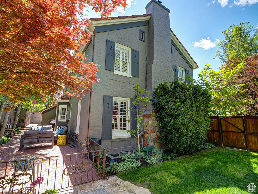 Back of property with an outdoor hangout area, a patio area, stucco siding, and a chimney