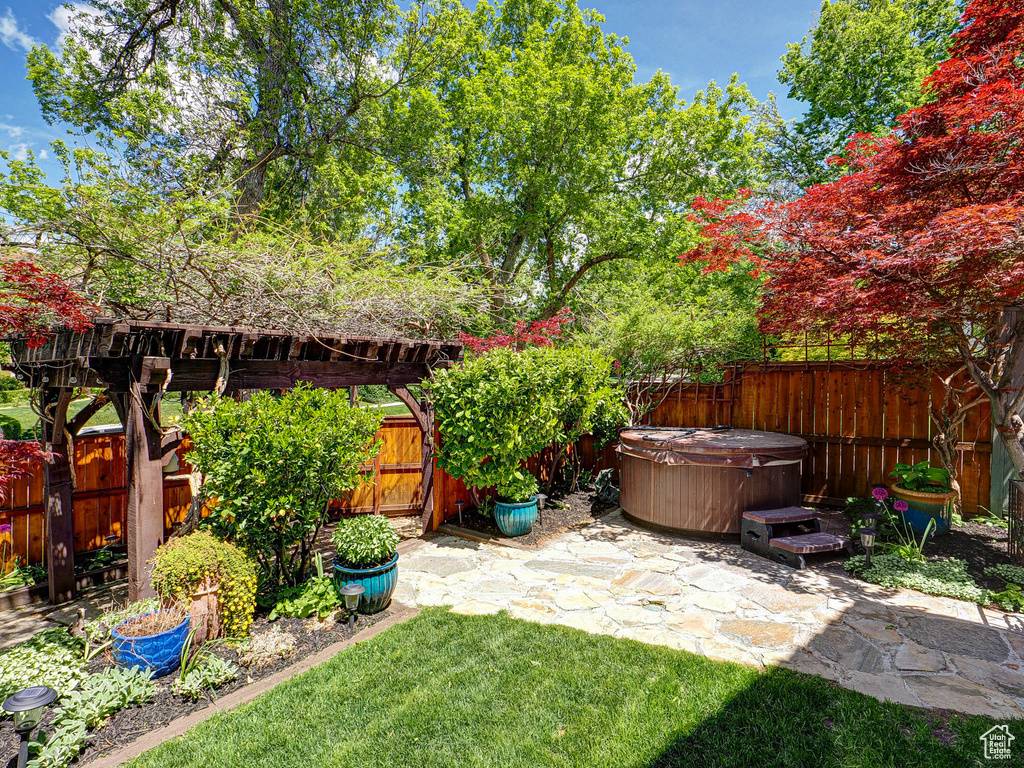 View of yard featuring a hot tub and a patio