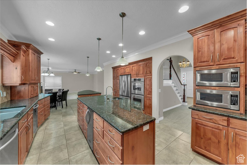 Kitchen with stainless steel appliances, ornamental molding, baseboards, recessed lighting, and a sink