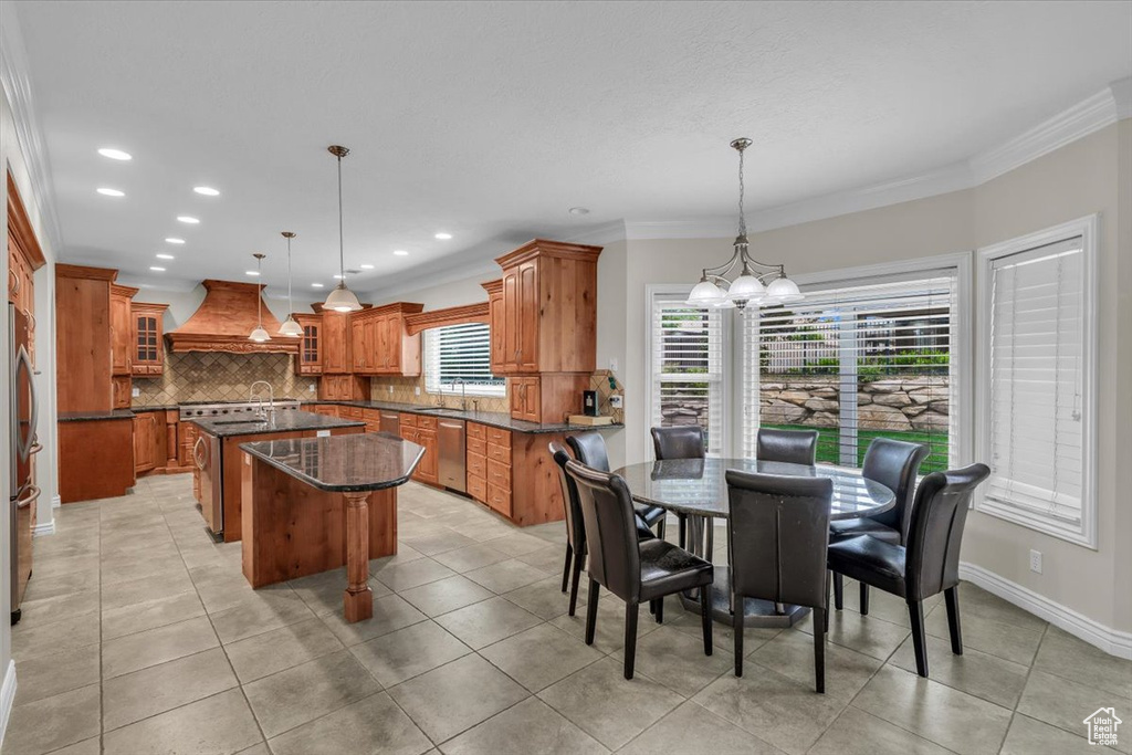 Dining area featuring a chandelier, ornamental molding, recessed lighting, light tile patterned floors, and baseboards