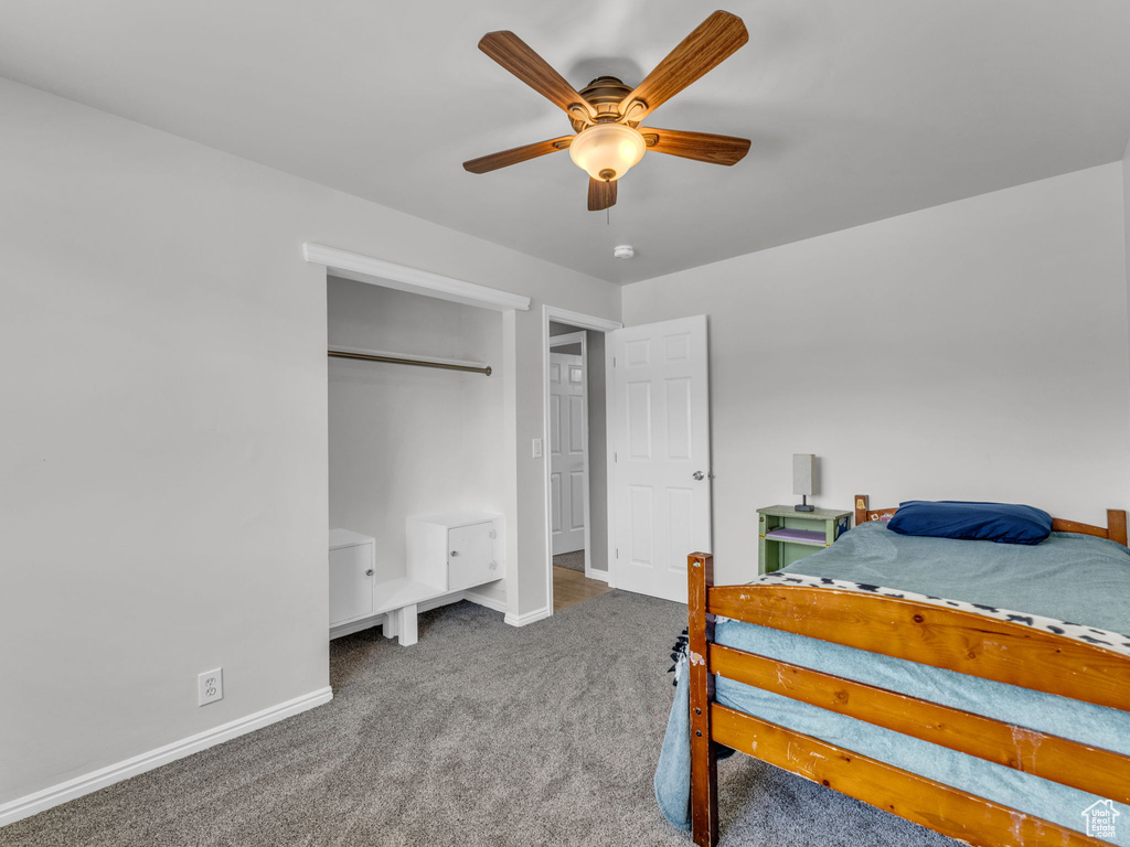 Carpeted bedroom with baseboards and a ceiling fan