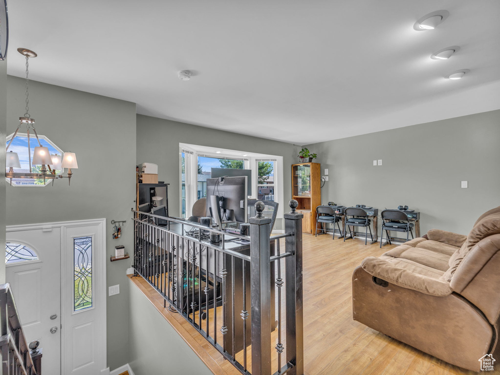 Entrance foyer with wood finished floors and a chandelier