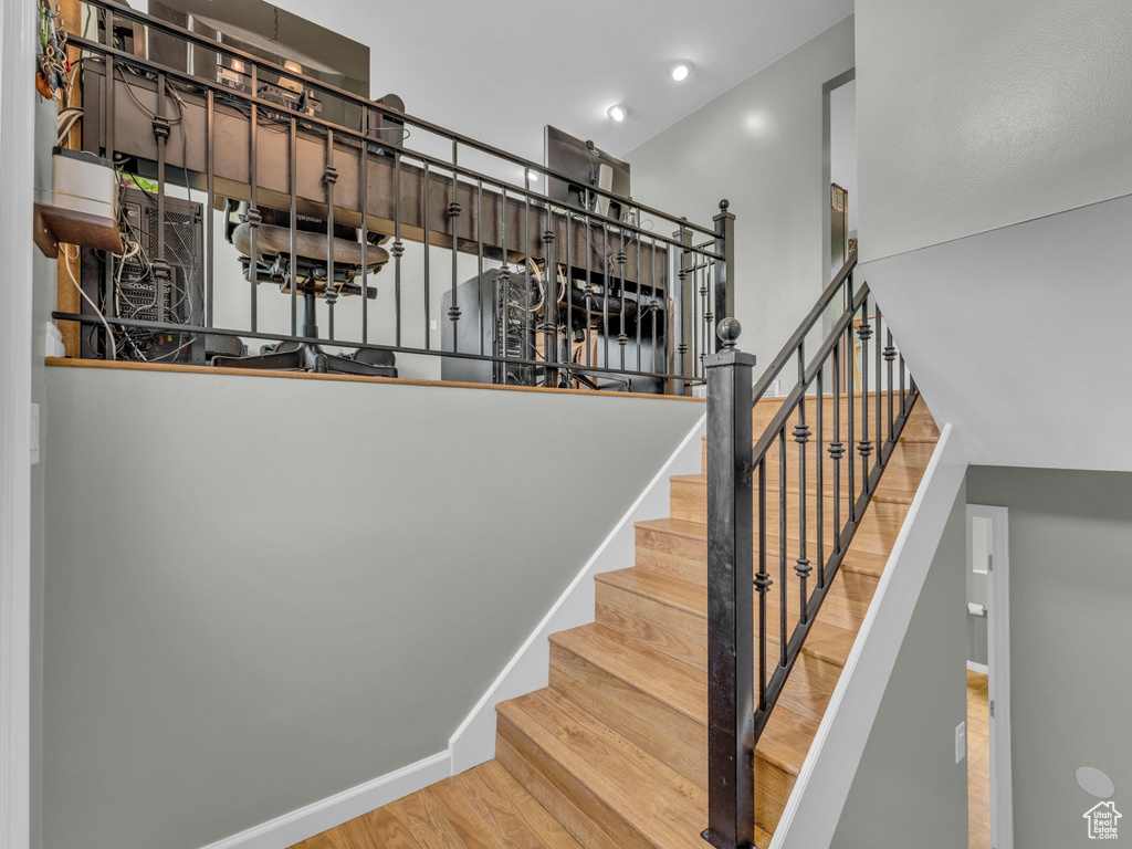 Stairway with wood finished floors and baseboards