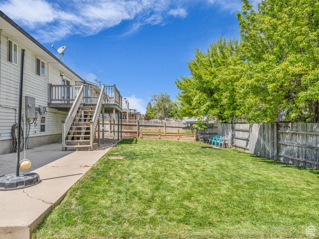 View of yard featuring stairs, a deck, and a patio area