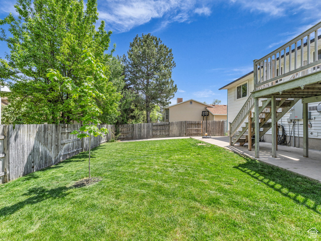 View of yard featuring a patio, a deck, and stairs