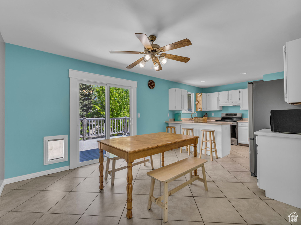 Dining area with ceiling fan, light tile patterned flooring, and baseboards