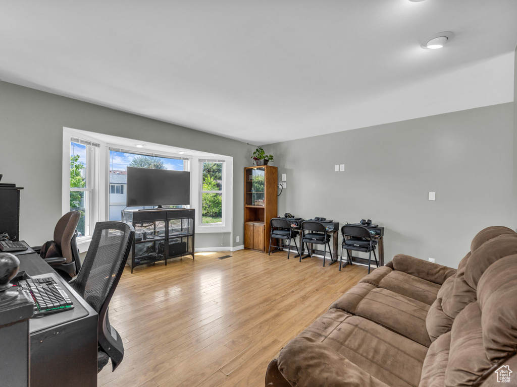 Living area with light wood-style floors and a desk
