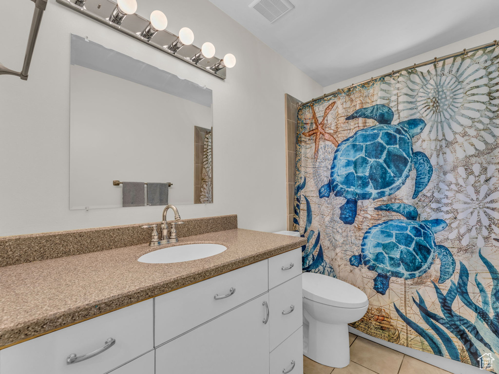 Bathroom featuring tile patterned floors, vanity, and toilet