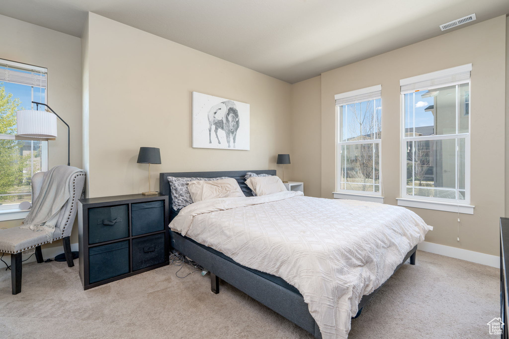 Bedroom with light colored carpet and baseboards
