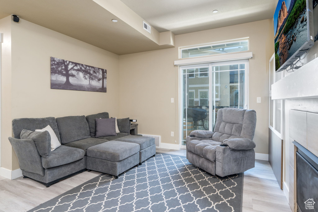 Living room featuring light wood-style floors, baseboards, and a fireplace