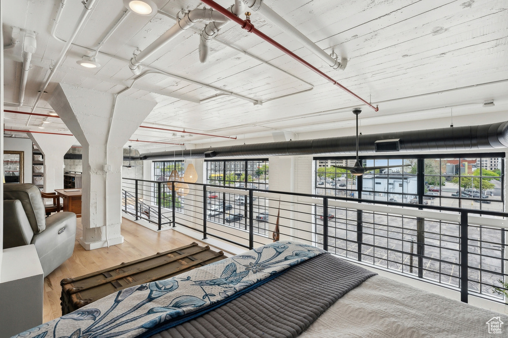 Bedroom with wood finished floors and multiple windows