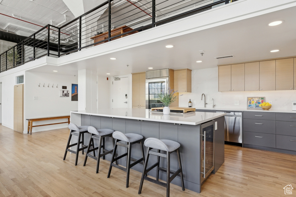 Kitchen with dishwasher, gray cabinets, a spacious island, modern cabinets, and a breakfast bar area