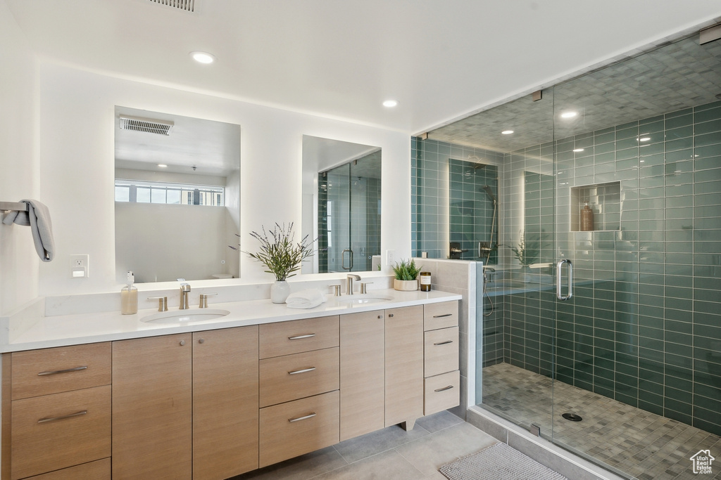 Bathroom with a stall shower, tile patterned flooring, double vanity, and recessed lighting