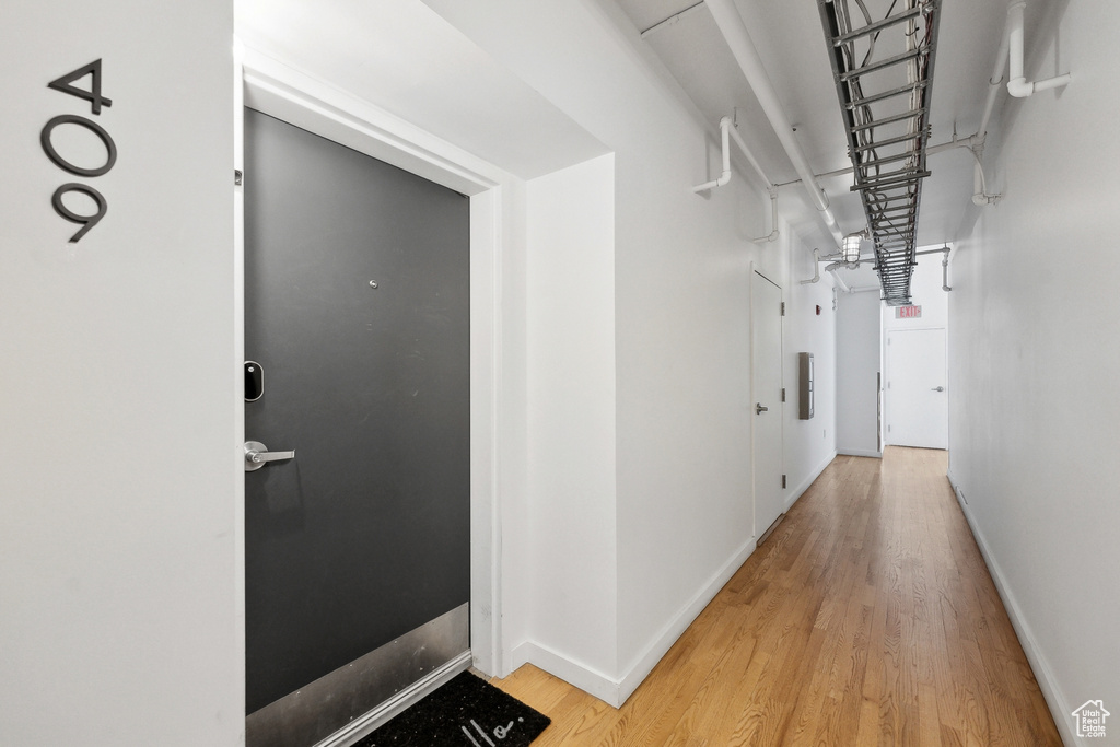Corridor featuring light wood-type flooring and baseboards