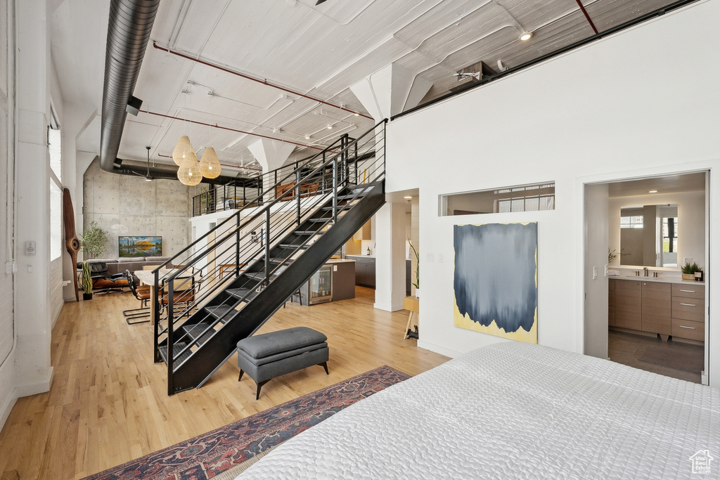 Stairs featuring a towering ceiling and wood finished floors