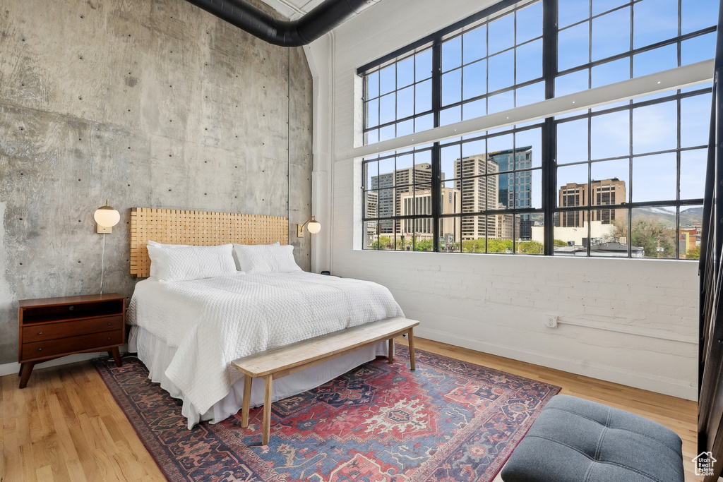 Bedroom featuring wood finished floors, a high ceiling, and baseboards