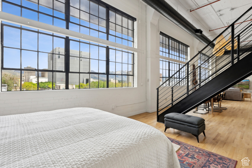 Bedroom with wood finished floors, a high ceiling, and baseboards