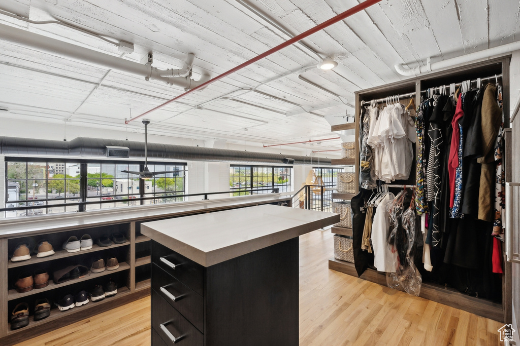 Walk in closet with light wood-style floors