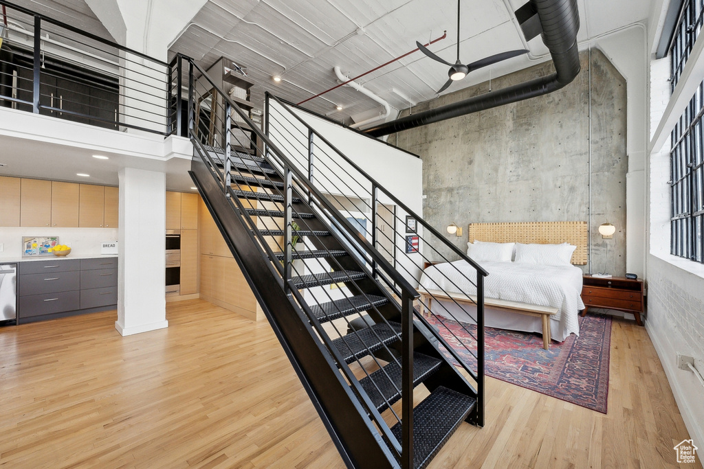 Staircase featuring wood finished floors and a high ceiling