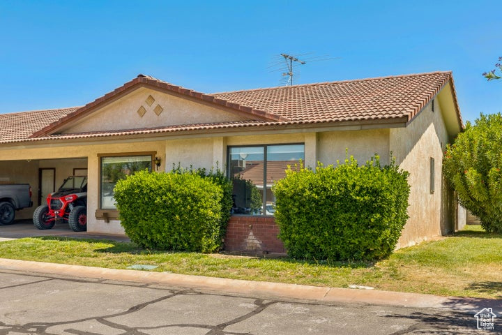 View of front of home featuring an attached carport and stucco siding