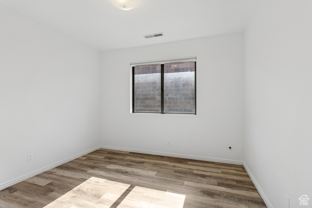 Spare room featuring wood finished floors and baseboards