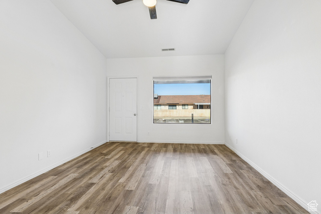 Spare room featuring a ceiling fan, wood finished floors, and baseboards
