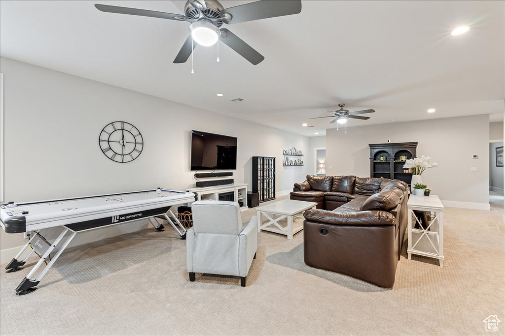 Living area featuring light colored carpet, a ceiling fan, recessed lighting, and baseboards
