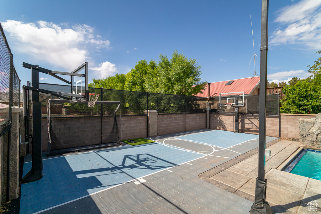 View of basketball court featuring basketball hoop and fence