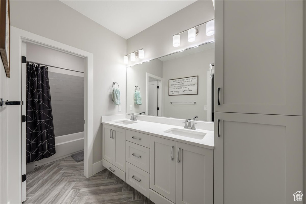 Bathroom with double vanity and shower / tub combo with curtain