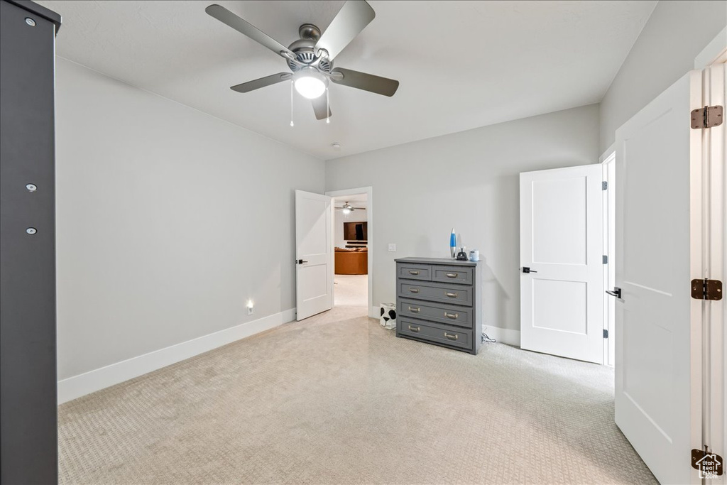 Bedroom with light carpet, baseboards, and ceiling fan