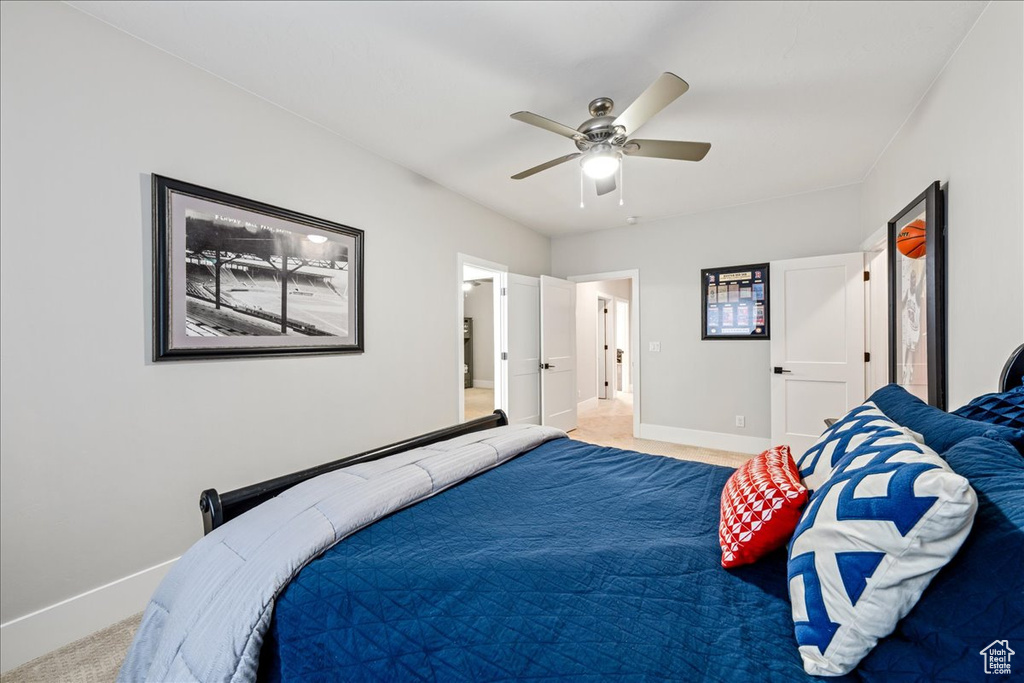 Bedroom with baseboards, light colored carpet, and ceiling fan