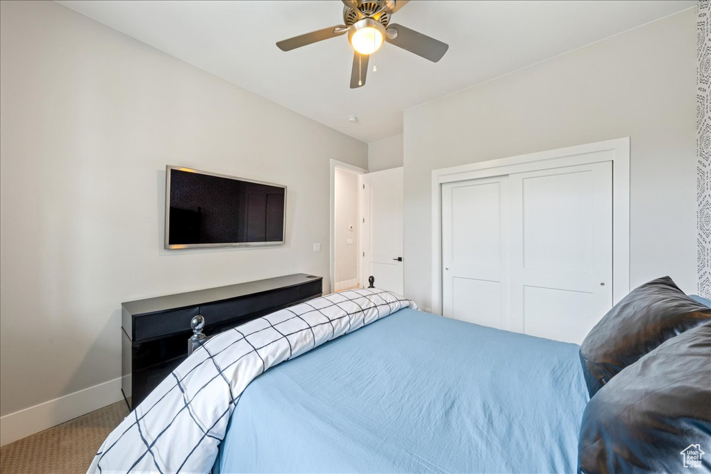 Bedroom featuring carpet floors, baseboards, a closet, and a ceiling fan