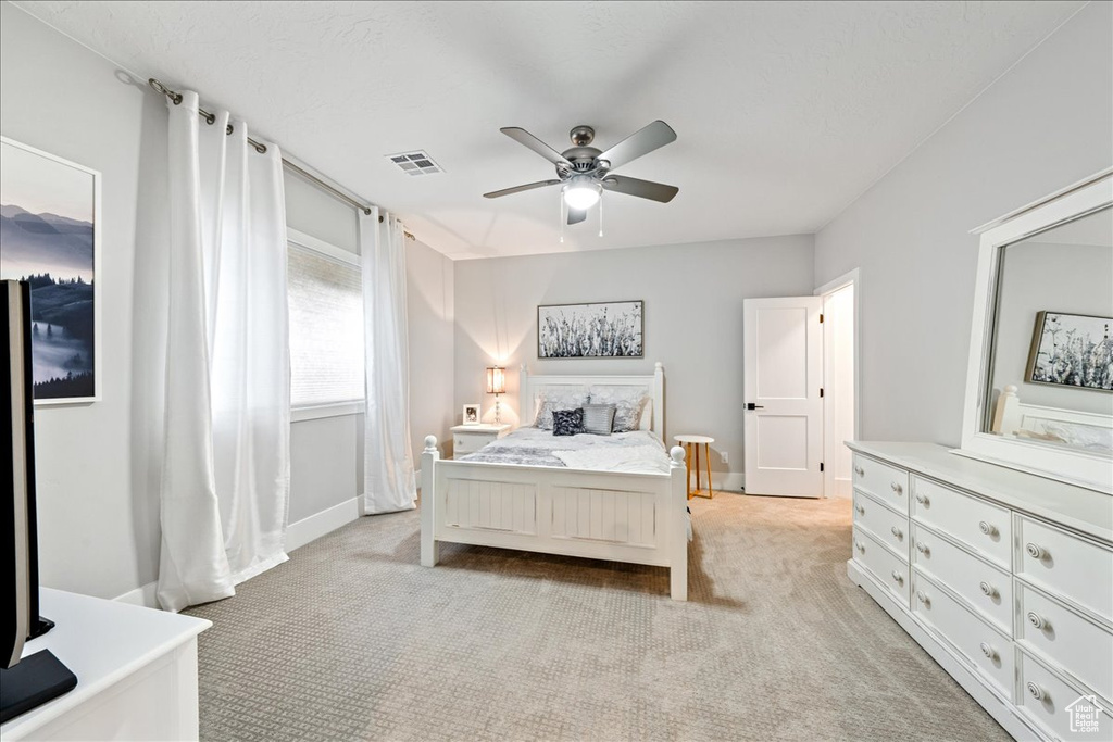 Bedroom featuring light colored carpet and a ceiling fan
