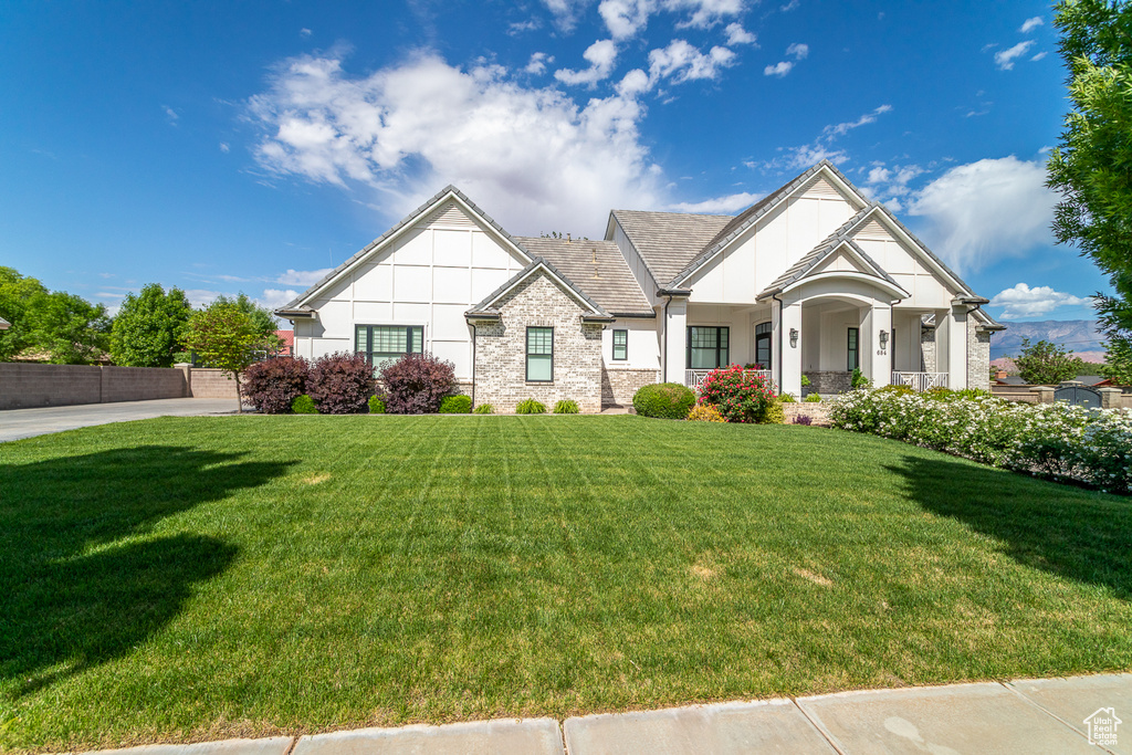 View of front of house with stone siding, a front lawn, and stucco siding