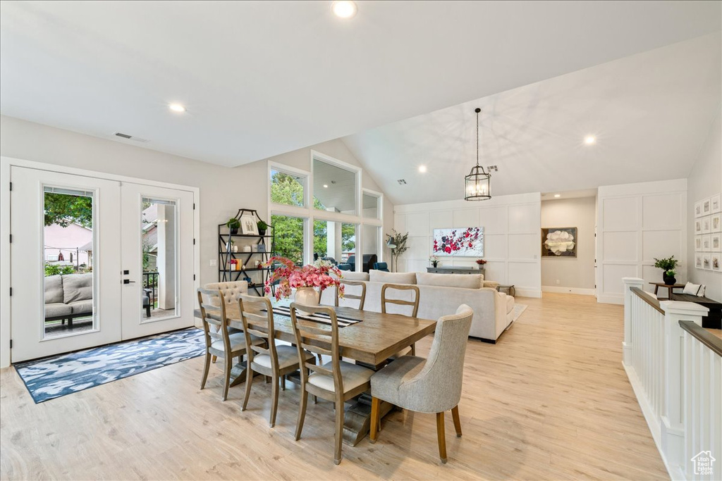 Dining space featuring light wood-style flooring, french doors, recessed lighting, vaulted ceiling, and a chandelier